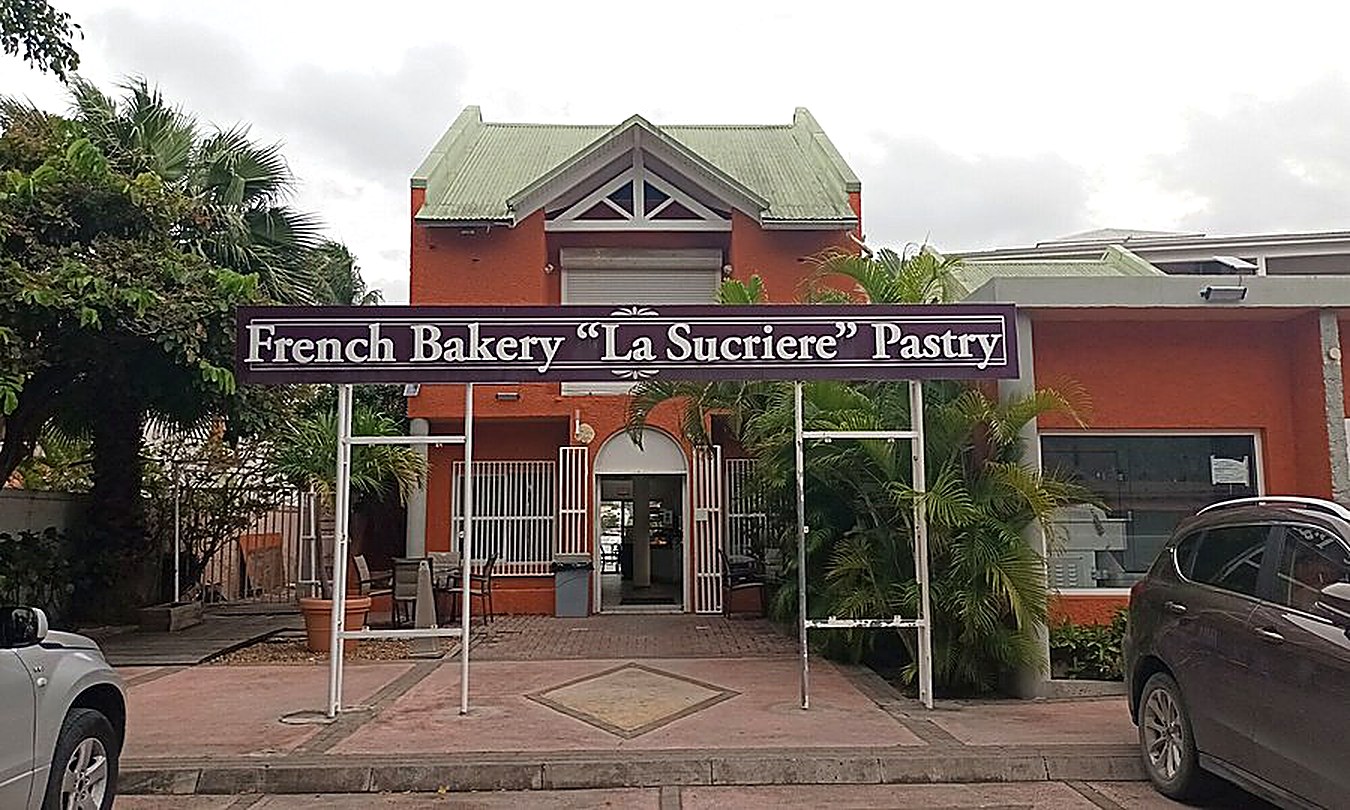 The original La Sucrière storefront on Welfare Road, Cole Bay, orange building with the French Bakery La Sucriere Pastry sign